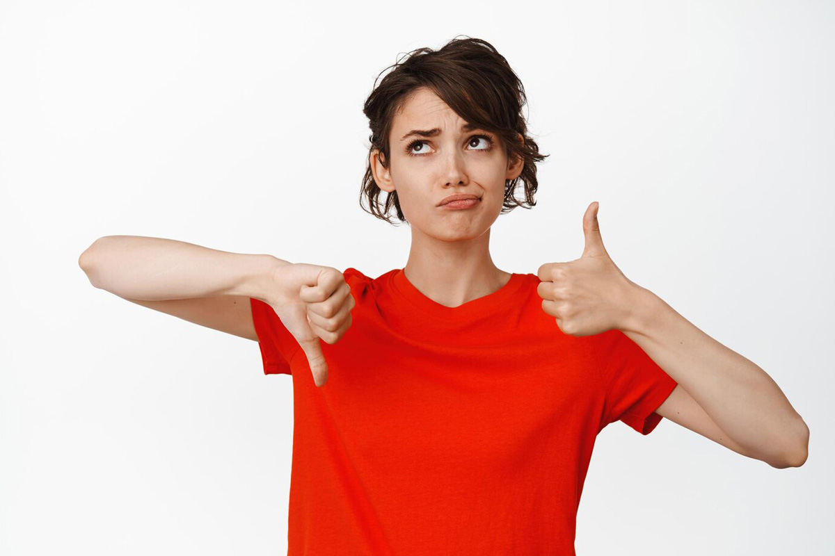 indecisive girl showing thumbs up thumbs down looking puzzled cannot make choice weighing pros cons white background 176420 47295